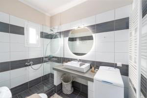 a bathroom with a sink and a toilet and a mirror at Meltemi Beach House - a seaside Luxury maisonnette in Dhiyeliótika +34 photos