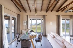 a living room with a table and a couch at Meltemi Beach House - a seaside Luxury maisonnette in Dhiyeliótika