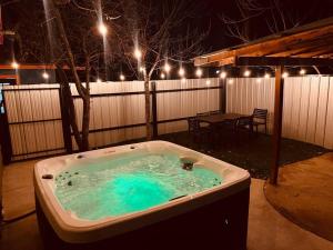 a hot tub in a yard with a table and lights at Prickly Pear at Cactus Flower-HOT TUB-Pet Friendly-No Pet Fees! in Albuquerque