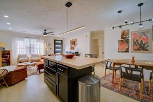 a kitchen and living room with a counter and a table at Prickly Pear at Cactus Flower-HOT TUB-Pet Friendly-No Pet Fees! in Albuquerque