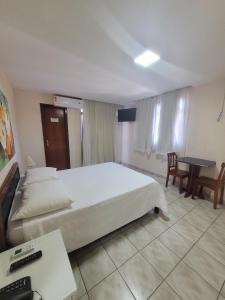 een hotelkamer met een bed en een bureau met een computer bij Hotel Marlin Azul in Iriri