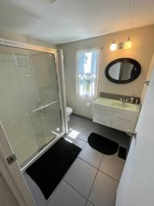 a bathroom with a shower and a sink and a mirror at Barooga: Stunning View Home in Halfmoon Bay, Canada in Halfmoon Bay