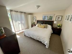 a bedroom with a bed and a large window at Barooga: Stunning View Home in Halfmoon Bay, Canada in Halfmoon Bay