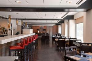 um restaurante com cadeiras e mesas vermelhas e um bar em Wyndham Boston Beacon Hill em Boston