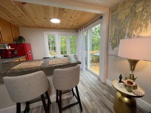 a kitchen with a bar with chairs and a table at Spacious 1 Bedroom Close to Everything 4 in Edgecomb