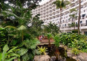 zwei Personen stehen auf einer Brücke in einem Garten in der Unterkunft Shangri-La Rasa Sentosa, Singapore in Singapur