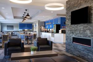 a restaurant with a fireplace and a bar at Days Inn & Suites by Wyndham Warman Legends Centre in Warman