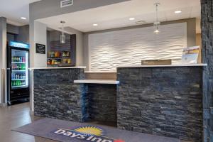 a bar in a restaurant with a stone wall at Days Inn & Suites by Wyndham Warman Legends Centre in Warman