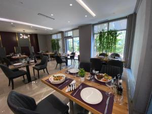 a dining room with tables and chairs with food on them at Doanesia Premium Hotel & Spa in Tirana