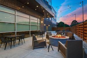 een patio met tafels en stoelen en een vuurplaats bij Four Points by Sheraton Fort Worth North in Fort Worth