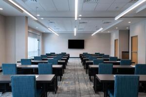 une pièce vide avec des tables, des chaises et un écran dans l'établissement Four Points by Sheraton Fort Worth North, à Fort Worth