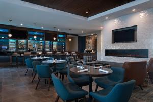 a restaurant with tables and chairs and a fireplace at Four Points by Sheraton Fort Worth North in Fort Worth
