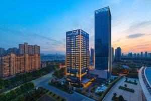 Courtyard by Marriott Luoyang في لويانغ: اطلالة جوية على مبنى طويل في مدينة