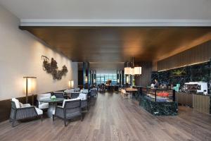 a lobby of a hotel with tables and chairs at Courtyard by Marriott Luoyang in Luoyang