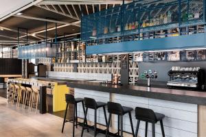 a restaurant with a bar with stools at Courtyard by Marriott Paris Creteil in Cr&eacute;teil