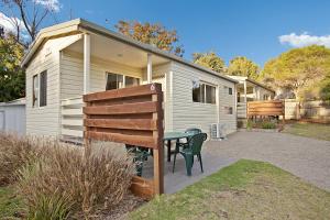 a house with a table and a bench in front of it at Kanasta Caravan Park in Rye