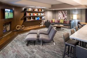 a living room with a couch and a fireplace at Courtyard by Marriott Portland North in Portland