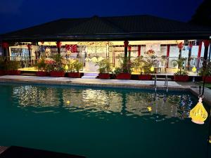 a house with a swimming pool in front of a building at Prodiges Hôtel in Yaoundé