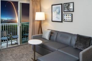 a living room with a couch and a balcony at Residence Inn by Marriott Cape Canaveral Cocoa Beach in Cape Canaveral