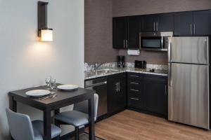 a kitchen with a small table and a refrigerator at Residence Inn by Marriott Cape Canaveral Cocoa Beach in Cape Canaveral