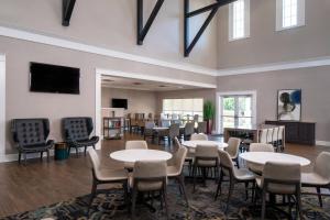 een grote kamer met tafels en stoelen en een tv bij Residence Inn by Marriott Cape Canaveral Cocoa Beach in Cape Canaveral