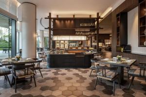 a restaurant with tables and chairs and a kitchen at Sheraton Ningbo Xiangshan Resort in Xiangshan