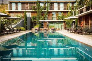 einen Pool mit Stühlen und Sonnenschirmen neben einem Gebäude in der Unterkunft Courtyard by Marriott Montpellier in Montpellier