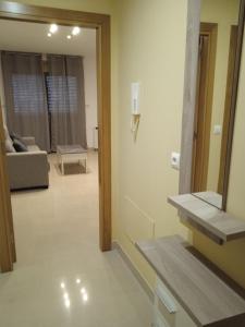 a room with a mirror and a living room with a couch at Apartamento Mirabel in Rosal
