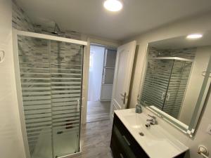 a bathroom with a shower and a sink and a mirror at Casa Los Cuncos in Barrio de Lomba