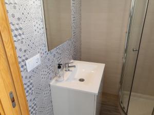 a bathroom with a white sink and a shower at La casita de la punta in Isla del Moral +8 photos