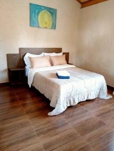 Un dormitorio con una cama con un libro. en Suites em São Thomé das Letras, en São Thomé das Letras