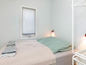 een witte slaapkamer met een bed en een raam bij Three-Bedroom Holiday home in Løkken 78 in Løkken