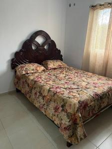 1 dormitorio con 1 cama con cabecero de madera en Residencial Nuevas Terrazas Aparment en Santo Domingo
