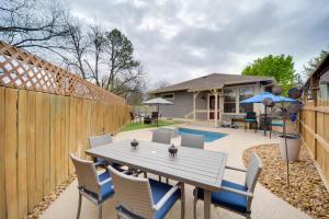 a backyard with a wooden fence and a table and chairs at Fredericksburg Home with Pool about 1 Mi to Main Street! in Fredericksburg
