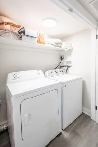 a white laundry room with a washer and dryer at Basement Master Bedroom in Mississauga