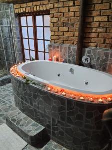 uma banheira com luzes de Natal na casa de banho em Ay Jay's Guesthouse em Bloemfontein