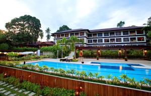 ein Hotel mit einem Schwimmbad vor einem Gebäude in der Unterkunft Hotel Tropika in Davao City + 22 Fotos