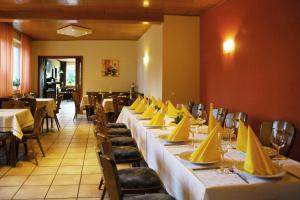une rangée de tables dans un restaurant avec des serviettes jaunes dans l'établissement Gasthaus-Witte, à Wallenhorst