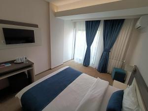 ein Hotelzimmer mit einem Bett und einem TV in der Unterkunft Aparthotel Mamaia in Mamaia