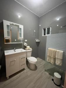 a bathroom with a white toilet and a sink at Apartamentos La Torre in Río San Juan