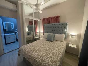 1 dormitorio con 1 cama grande y espejo en Apartamentos La Torre en Río San Juan
