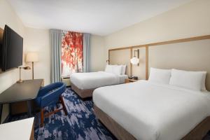 a hotel room with two beds and a desk at Fairfield Inn & Suites Worcester Auburn in Auburn
