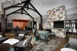 Residence Inn by Marriott Milwaukee Brookfield في بروكفيلد: غرفة معيشة مع موقد وتلفزيون