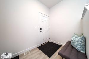 a living room with a couch and a door at *New*Chic Modern Home*King bed*Foosball*Sleeps 8! in Edmonton