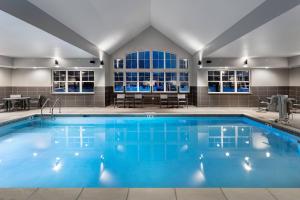 a large pool with blue water in a building at Residence Inn by Marriott Milwaukee Brookfield in Brookfield