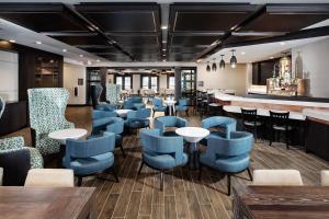 un restaurant avec des chaises bleues et un bar dans l'établissement Residence Inn by Marriott Milwaukee Brookfield, à Brookfield