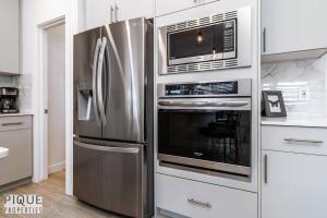 a kitchen with a stainless steel refrigerator and microwave at *New*Chic Modern Home*King bed*Foosball*Sleeps 8! in Edmonton