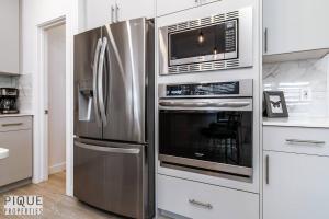 a kitchen with a stainless steel refrigerator and microwave at *New*Chic Modern Home*King bed*Foosball*Sleeps 8! in Edmonton +59 photos