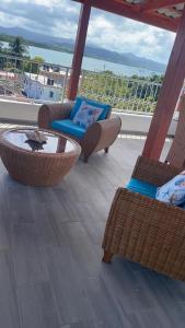 a balcony with wicker chairs and a table with a view of the ocean at Apartamentos La Torre in Río San Juan