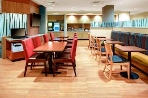 uma sala de jantar com mesas e cadeiras de madeira em TownePlace Suites by Marriott Macon Mercer University em Macon